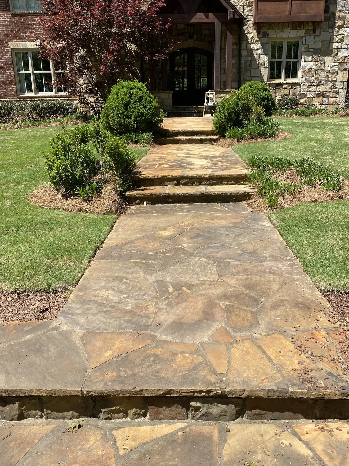 A washed flagstone walkway leading to a stone home